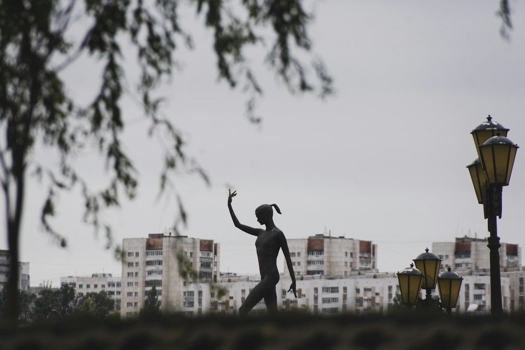 Mörk figurativ skulptur och dekorativa lyktor på ett torg